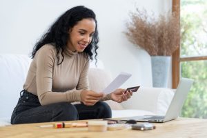 Femme remplissant une demande de crédit sur son ordinateur portable à la maison